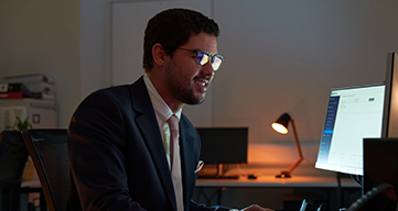 Professional working at a desk using a desktop computer in a modern office environment