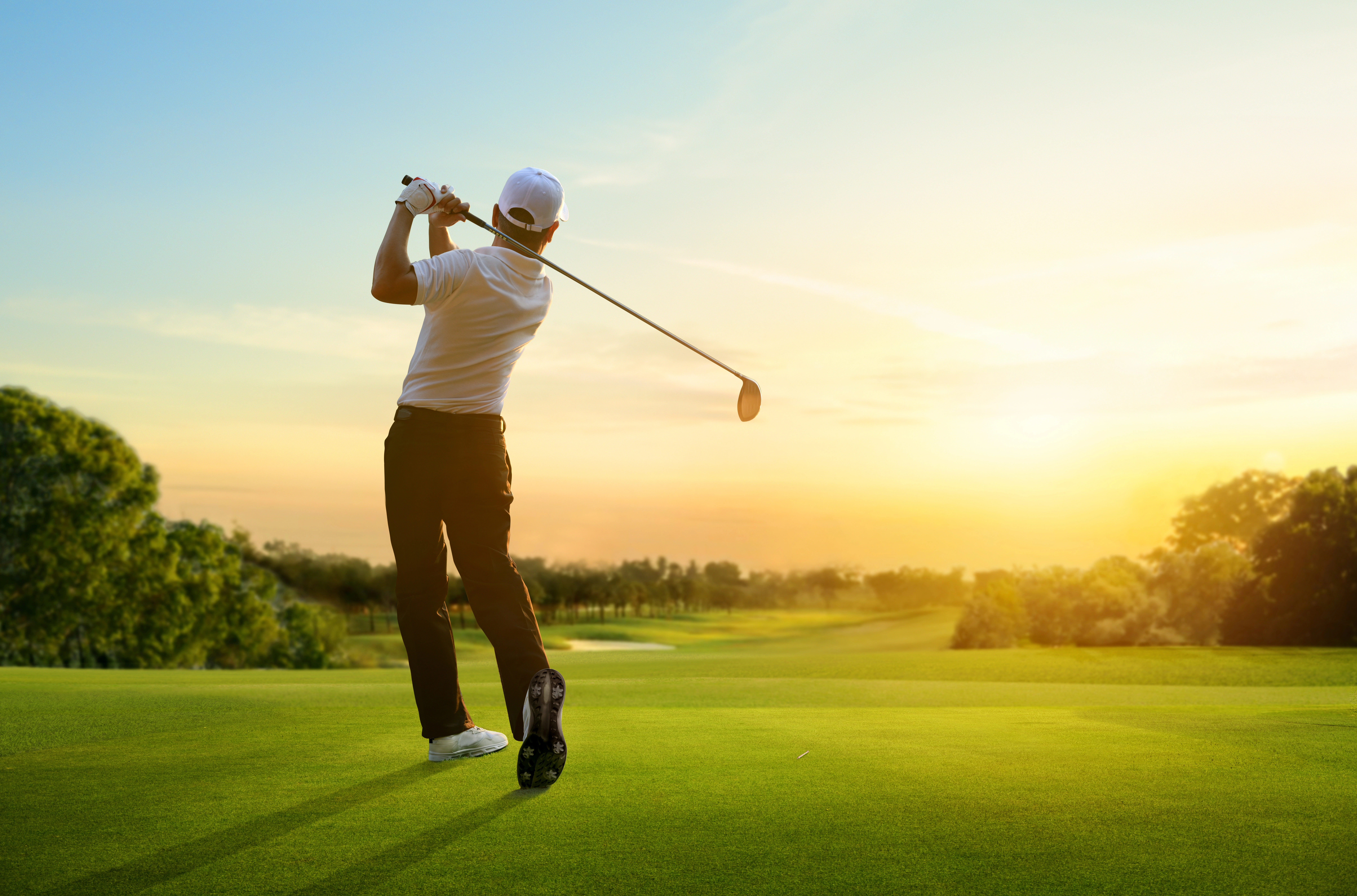 Customers playing golf at sunset